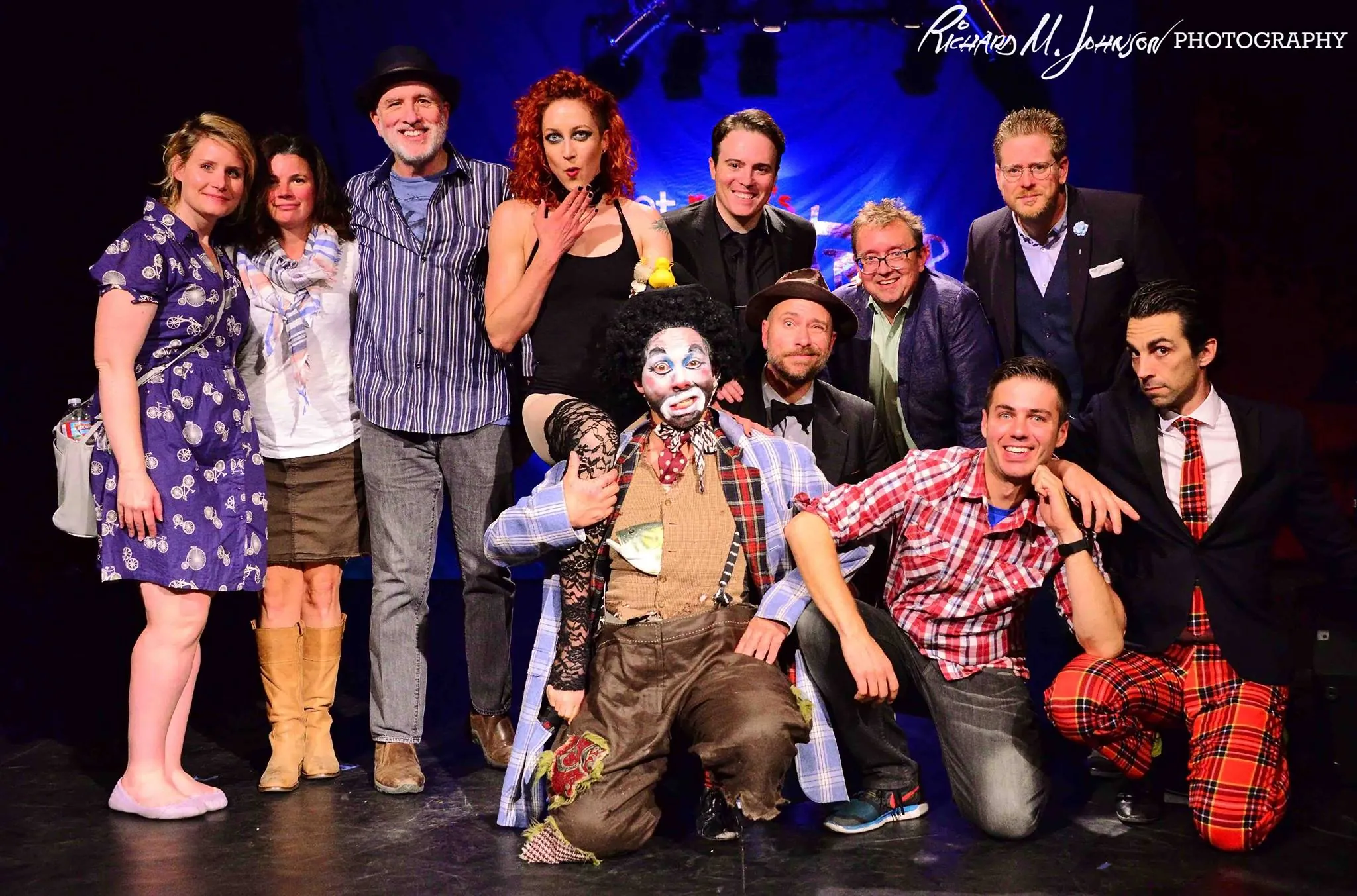 A cast of comedians, clowns, musicians and variety artists posing together on the Fais Do-Do stage after a show