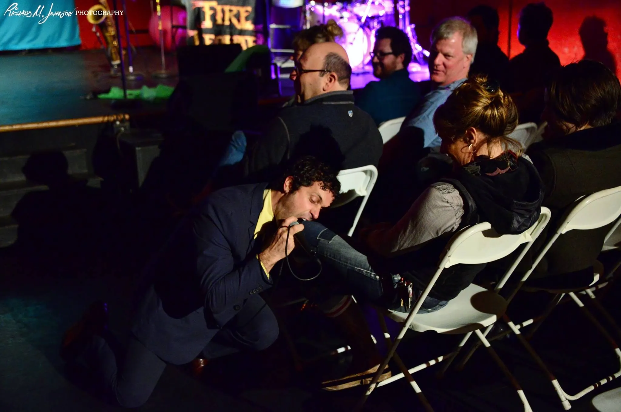 Performer kneeling in the audience among the seats